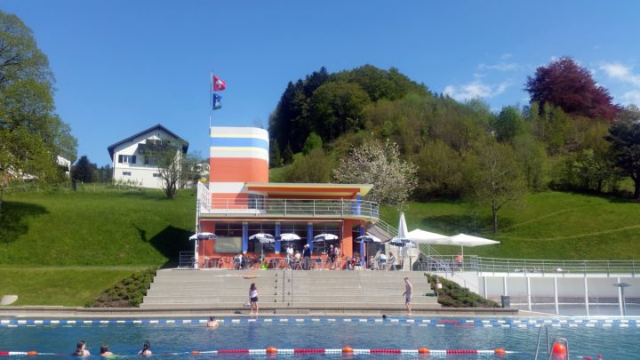 Die ersten Gäste. Die Mutigen im kühlen Wasser und die Neugierigen im Badi-Restaurant bei der neuen Pächterin.